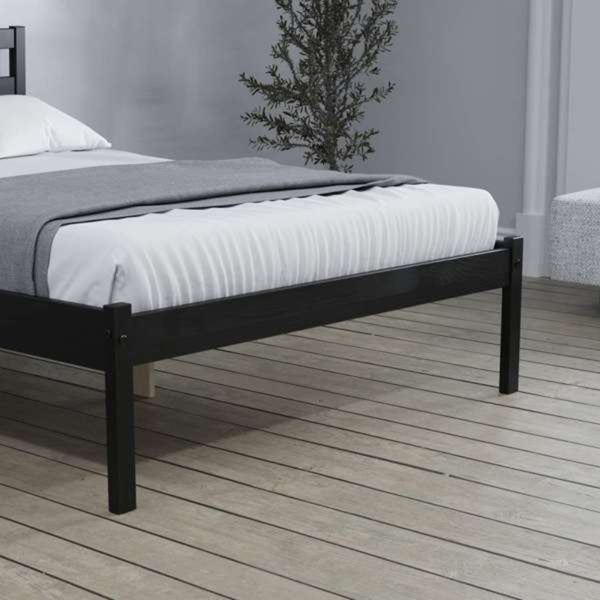 Bed with black frame and white bedding on a wooden floor.