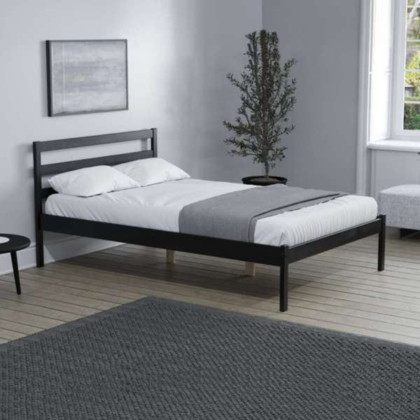 Black metal bed frame with white bedding in a modern bedroom.