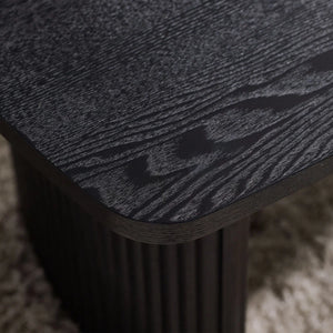 Close-up of a textured black surface on a wooden stool.