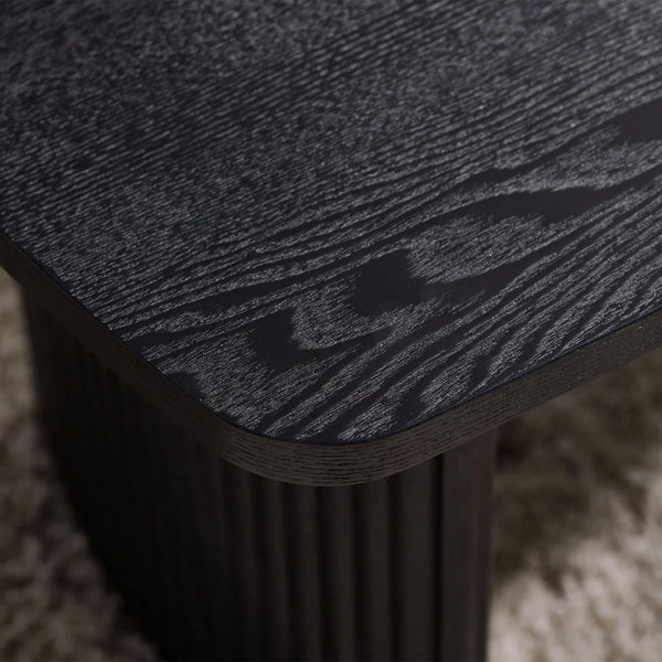 Close-up of a textured black surface on a wooden stool.
