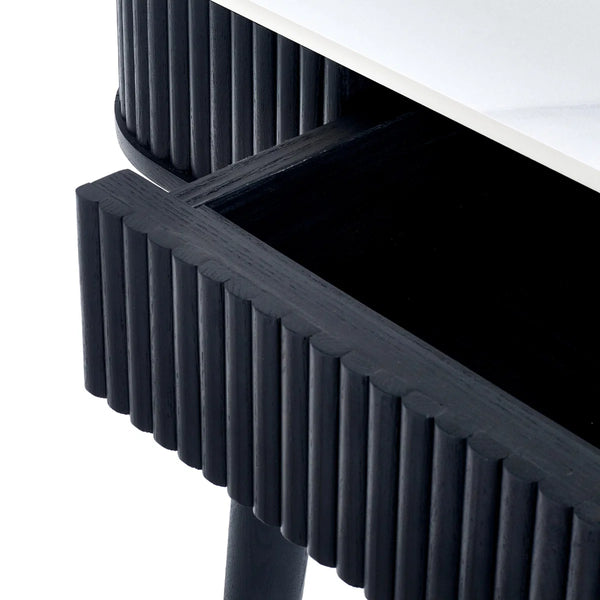 Close-up of a black textured side table with a white surface.