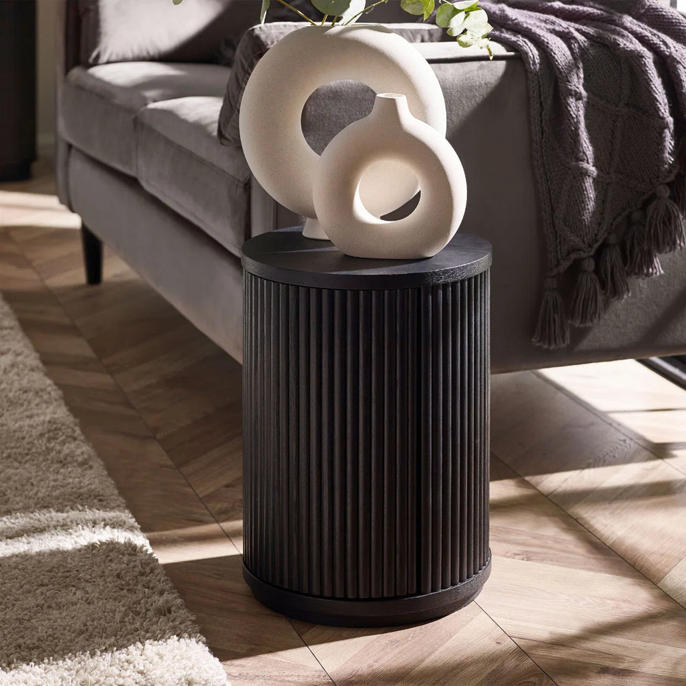 Black cylindrical side table on a white background
