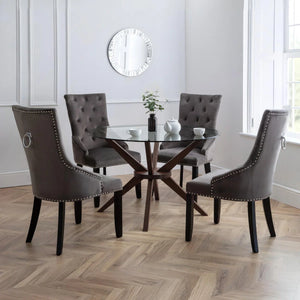 Dining room with a glass table and GREY chairs on a wooden floor.