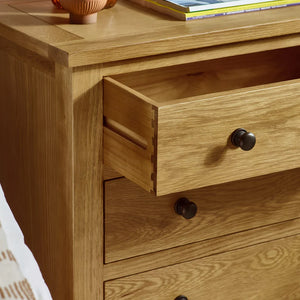 Wooden dresser with open drawer and black knobs