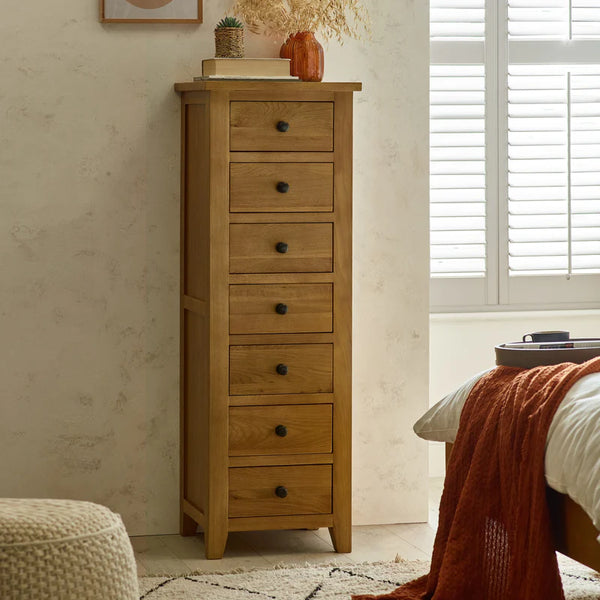 Wooden tall dresser with drawers in a bedroom setting