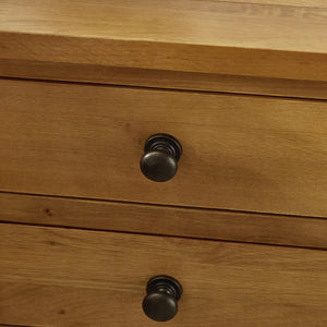 Close-up of a wooden drawer with black knobs