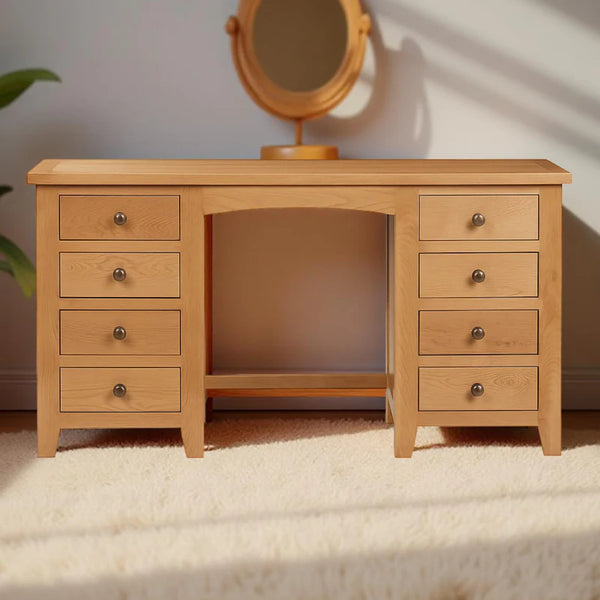 Wooden vanity with multiple drawers and a mirror on a carpeted floor.