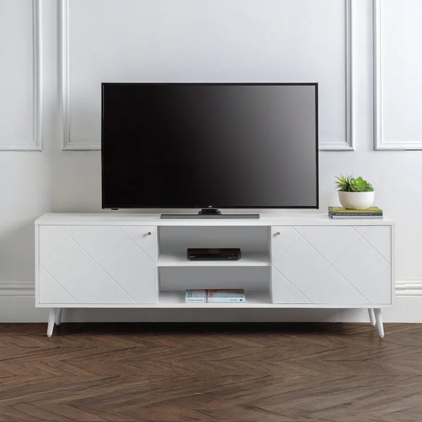 White TV stand with a black TV on top in a room with wooden flooring and white walls.