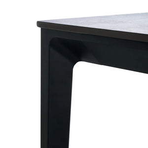 Close-up of a black metal table leg with a white surface.