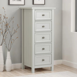 White dresser with four drawers in a room with gray walls and wooden flooring.