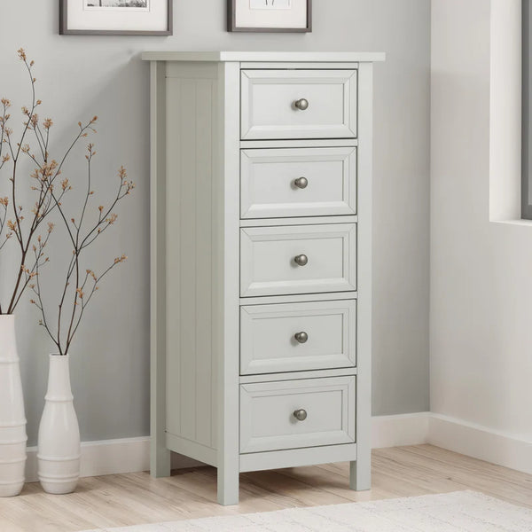 White dresser with four drawers in a room with gray walls and wooden flooring.