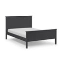 Black bed frame with white mattress on a light gray background