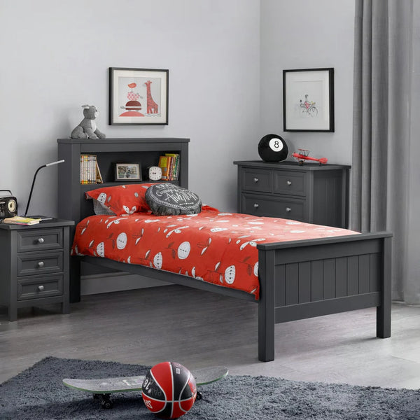 Children's bedroom with gray bed frame, red bedding, and sports-themed decor.