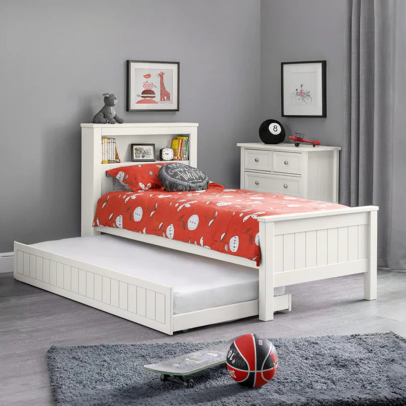 White bed with red bedding and a bookshelf headboard on a white background
