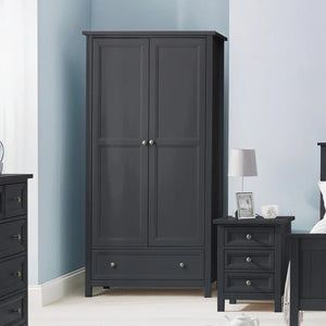 Black wardrobe with two doors and a drawer in a bedroom setting.