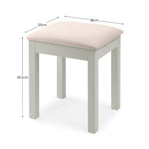 Small stool with a pink cushioned top and measurements on a white background