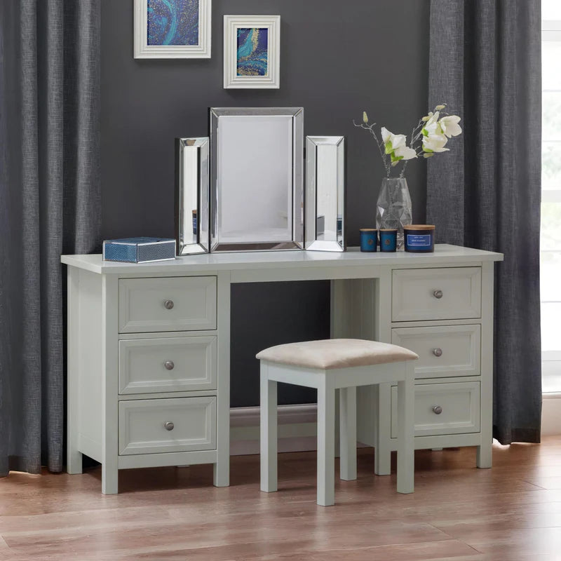 Gray desk with multiple drawers and a matching stool with a beige cushion on a white background