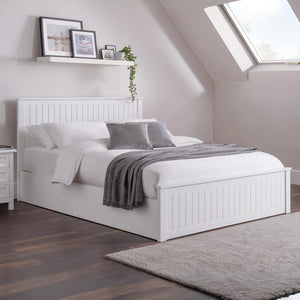 White bed in a bedroom with wooden floor and skylight