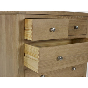 Wooden dresser with three drawers and metallic handles on a white background