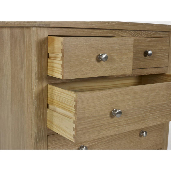 Wooden dresser with three drawers and metallic handles on a white background