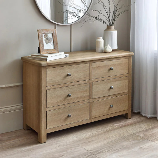 Wooden dresser with four drawers in a room setting.