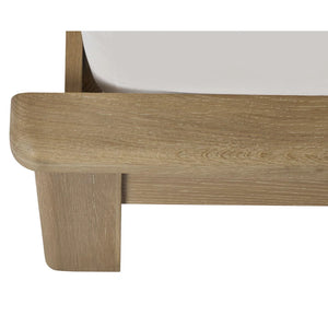 Close-up of a wooden bed frame corner with a white mattress.