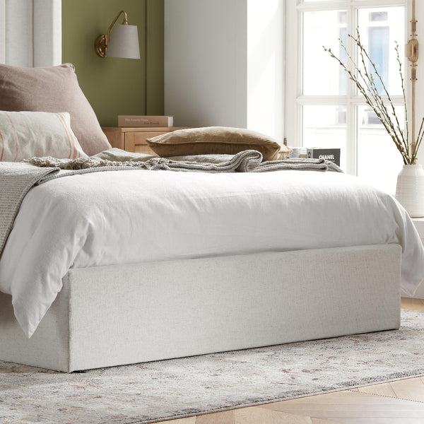 Neatly made bed with white bedding in a bright bedroom