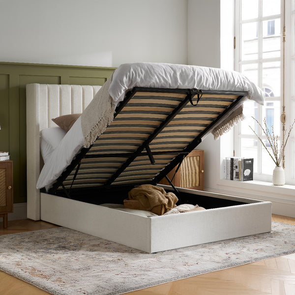 White bed with open storage compartment in a bright room