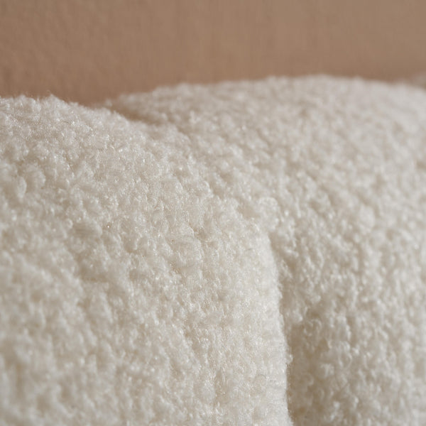 Close-up of a textured white fabric against a brown background