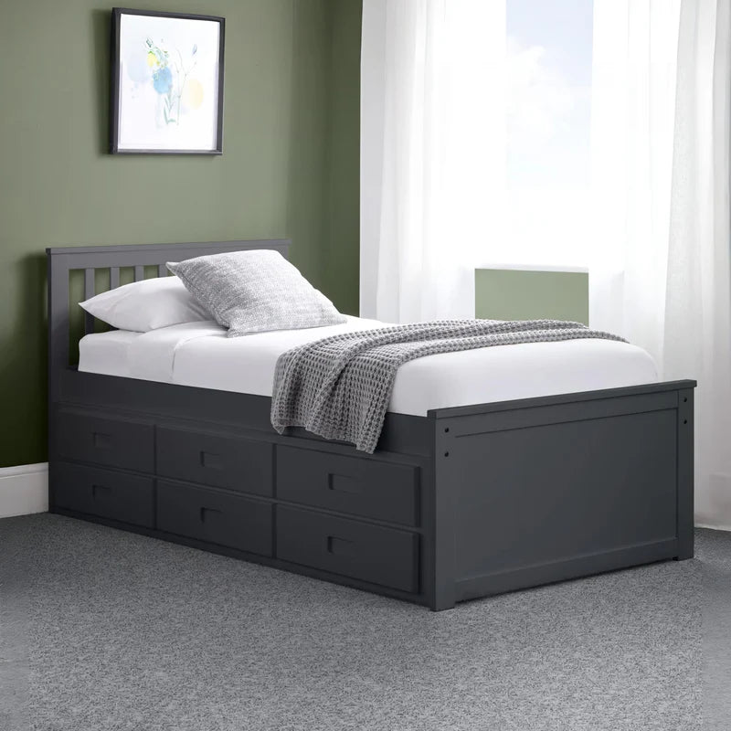 Black bed frame with pull-out trundle and white bedding on a white background