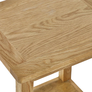 Close-up of a wooden side table with a light brown finish.