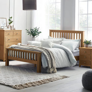 Wooden bed with white bedding in a bright bedroom setting