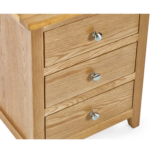 Wooden dresser with three drawers and metal knobs on a white background