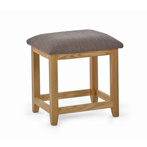 Wooden stool with a gray cushioned top on a white background