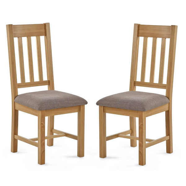 Two wooden chairs with gray cushioned seats on a white background