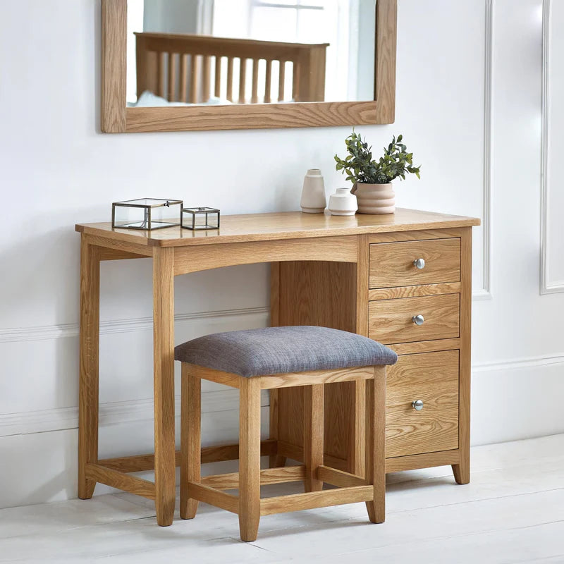 Wooden desk with a cushioned stool on a white background