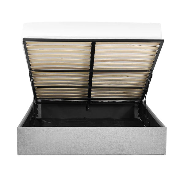 Gray upholstered bed with open storage compartment on a white background