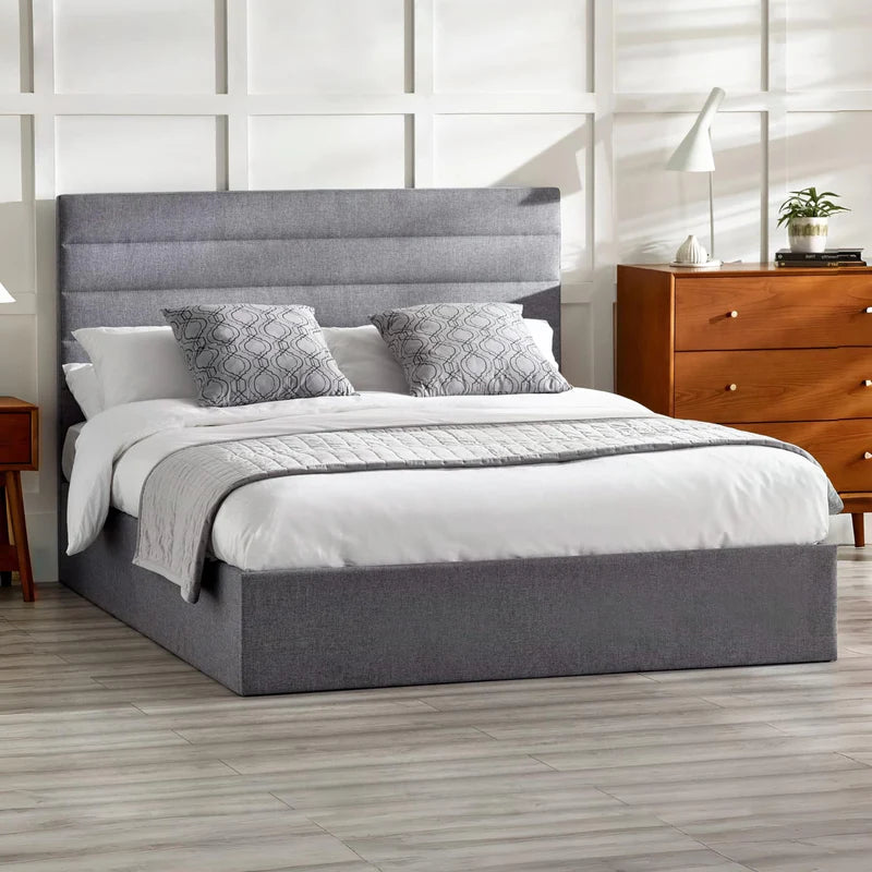 Gray upholstered bed frame with white mattress on a white background
