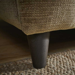 Close-up of a textured fabric surface with a dark wooden leg.