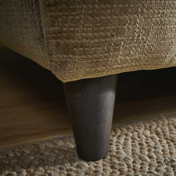 Close-up of a textured fabric surface with a dark wooden leg.