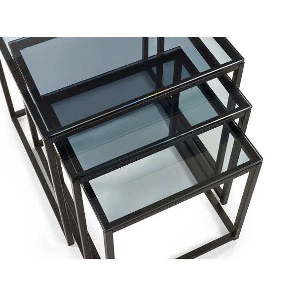 Set of three black metal nesting tables with glass tops on a white background