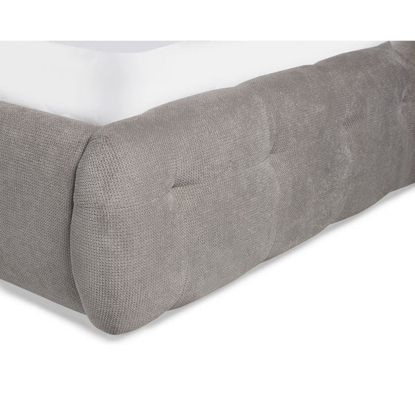 Gray textured fitted sheet on a bed with a white background
