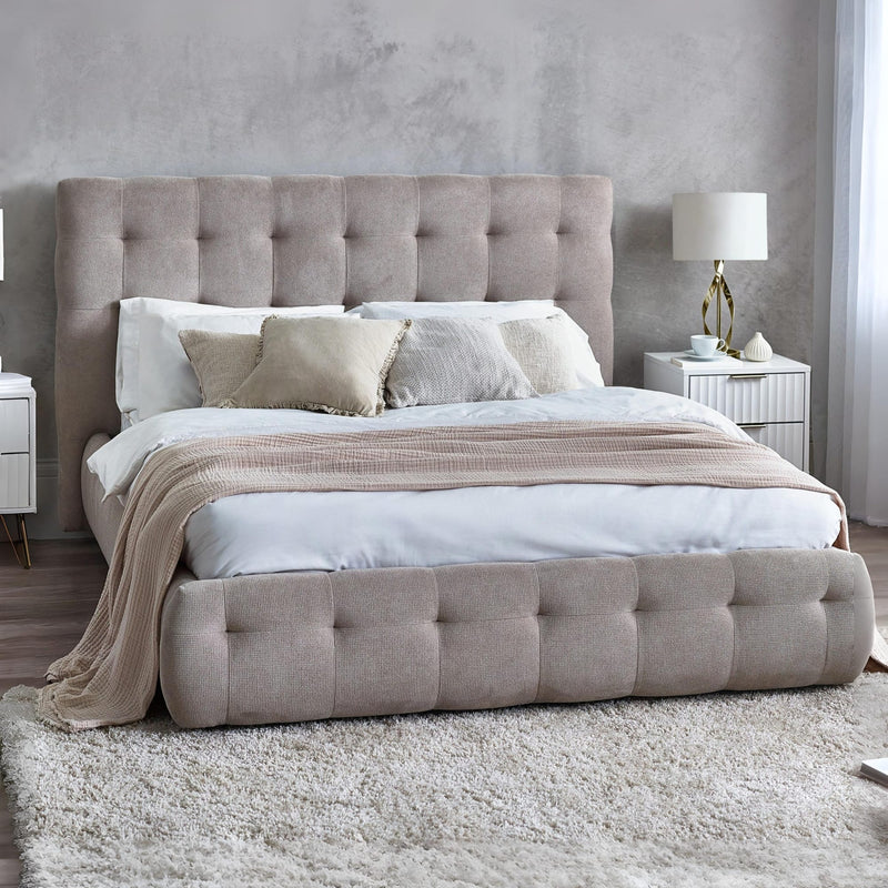 Gray upholstered bed with tufted design on a white background