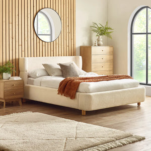 cream bed frame in a modern bedroom with slatted wall behind