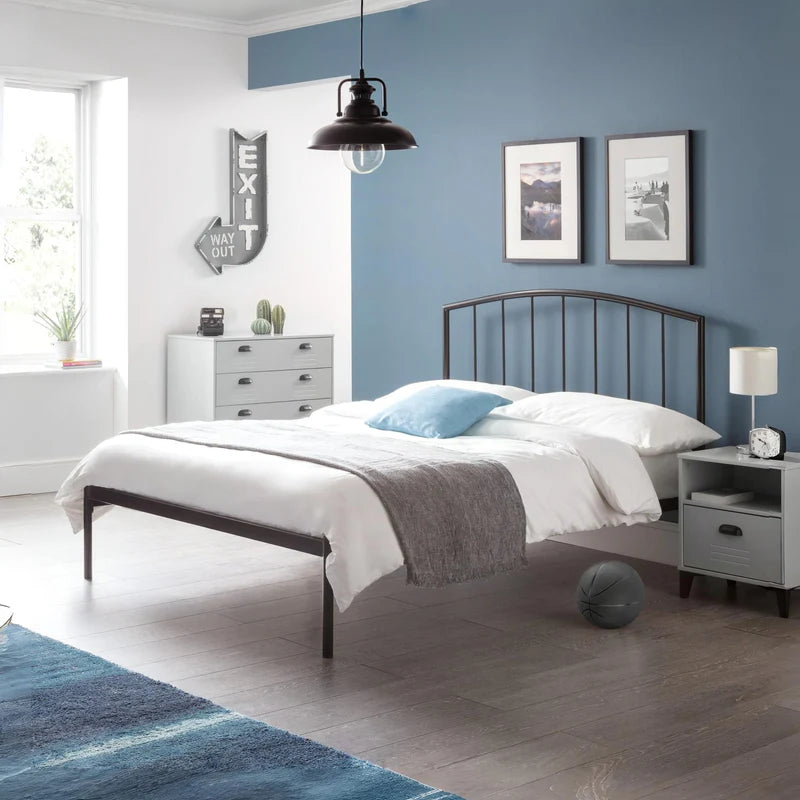 Black metal bed frame with white mattress on a white background