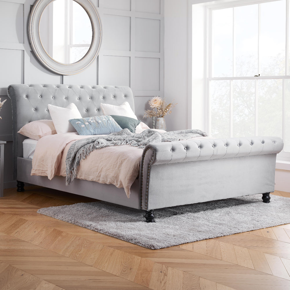 Gray upholstered bed with white mattress on a white background