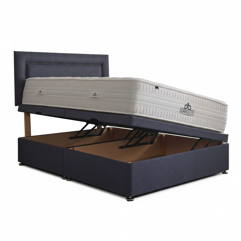 Blue bed frame with open storage compartment and mattress on a white background