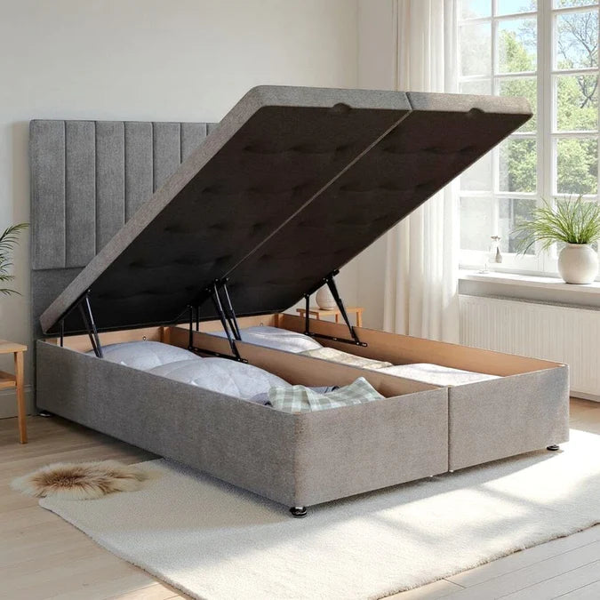 Gray upholstered bed with storage compartments in a bright room.