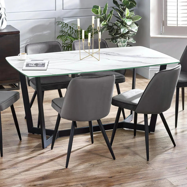 Dining room with a glass table and gray chairs on a wooden floor.