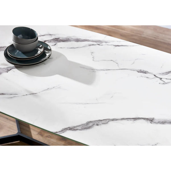 Marble-patterned table top on a wooden table with black and white dishes.